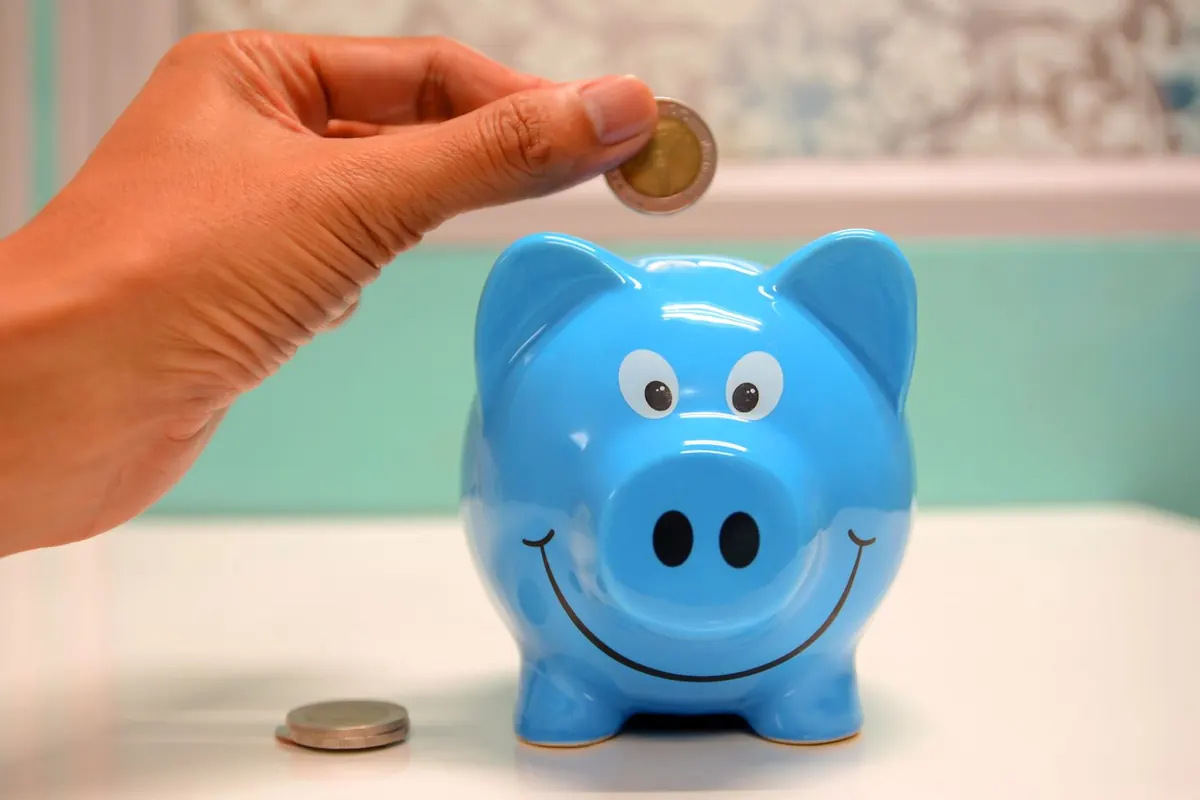 A glass jar full of coins next to financial documents, representing high-yield savings