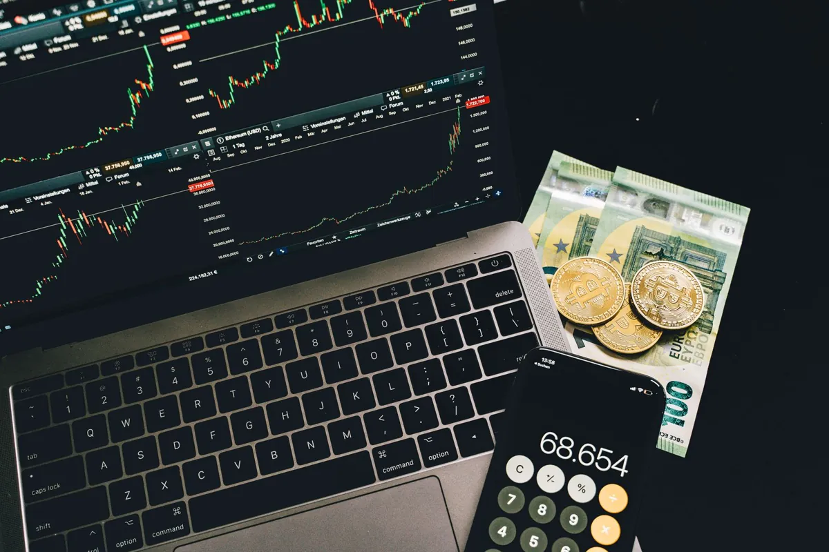 Tax forms and a laptop showing crypto transactions, representing how to report digital-asset taxes correctly