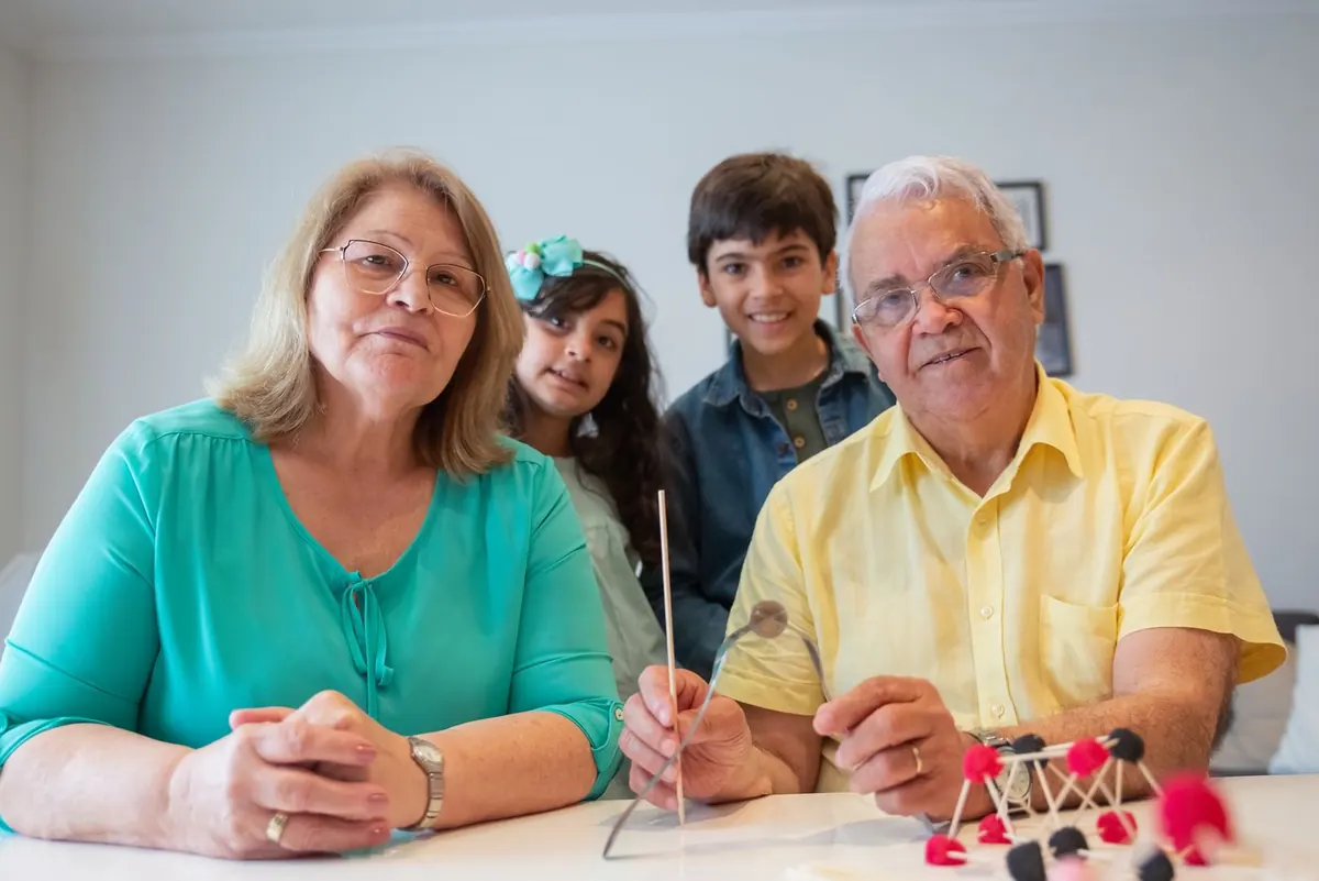 Grands-parents et petits-enfants réunis autour d'une table, symbole de la transmission entre générations