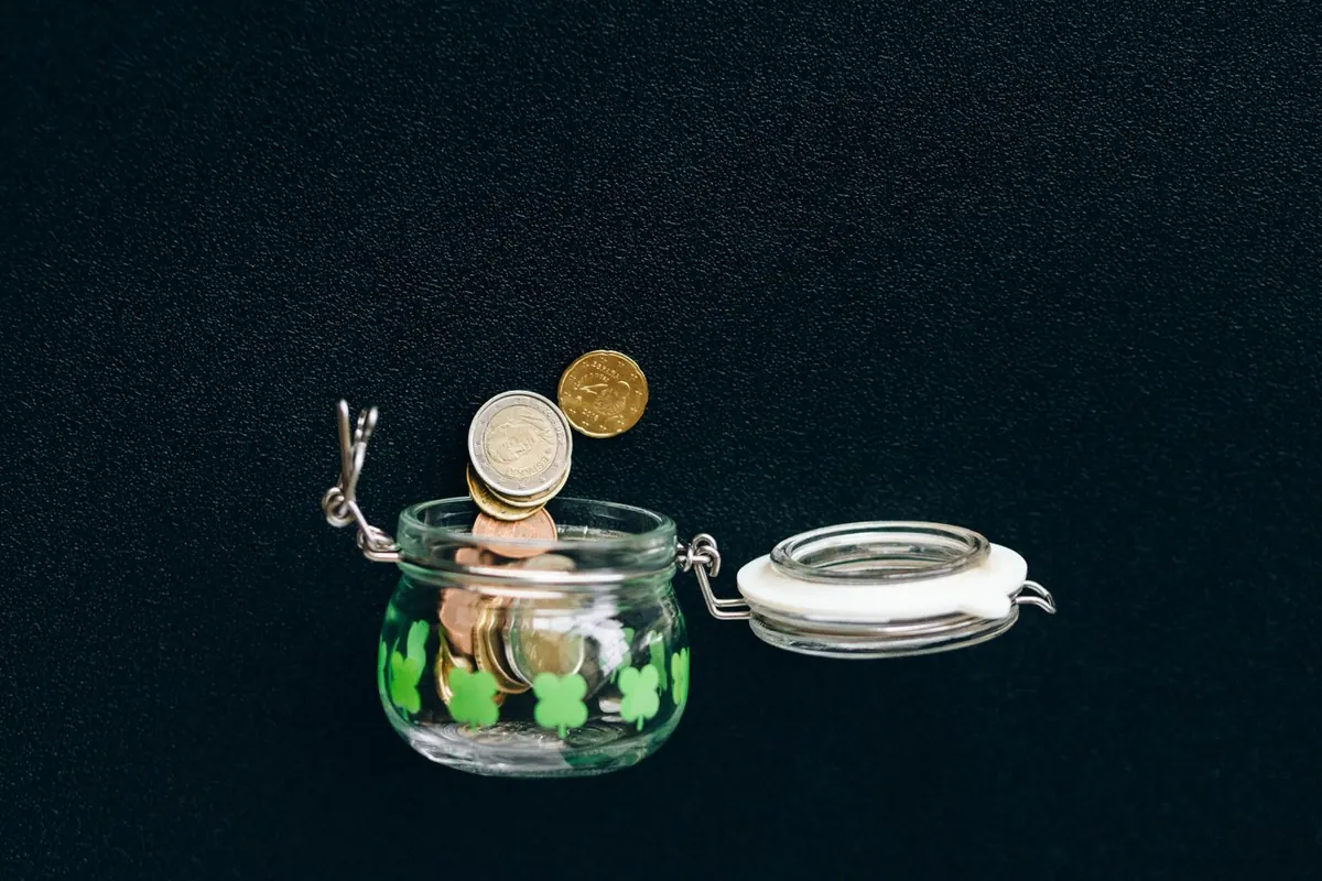 Un bocal en verre rempli de pièces en euros, symbole de faire fructifier son argent en investissant