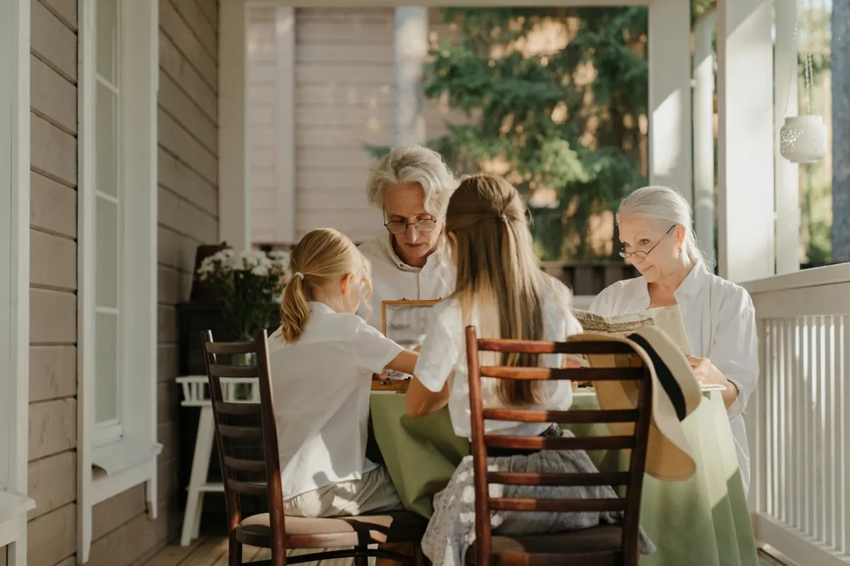 Grandparents and grandchildren together on a house porch, representing passing wealth between generations
