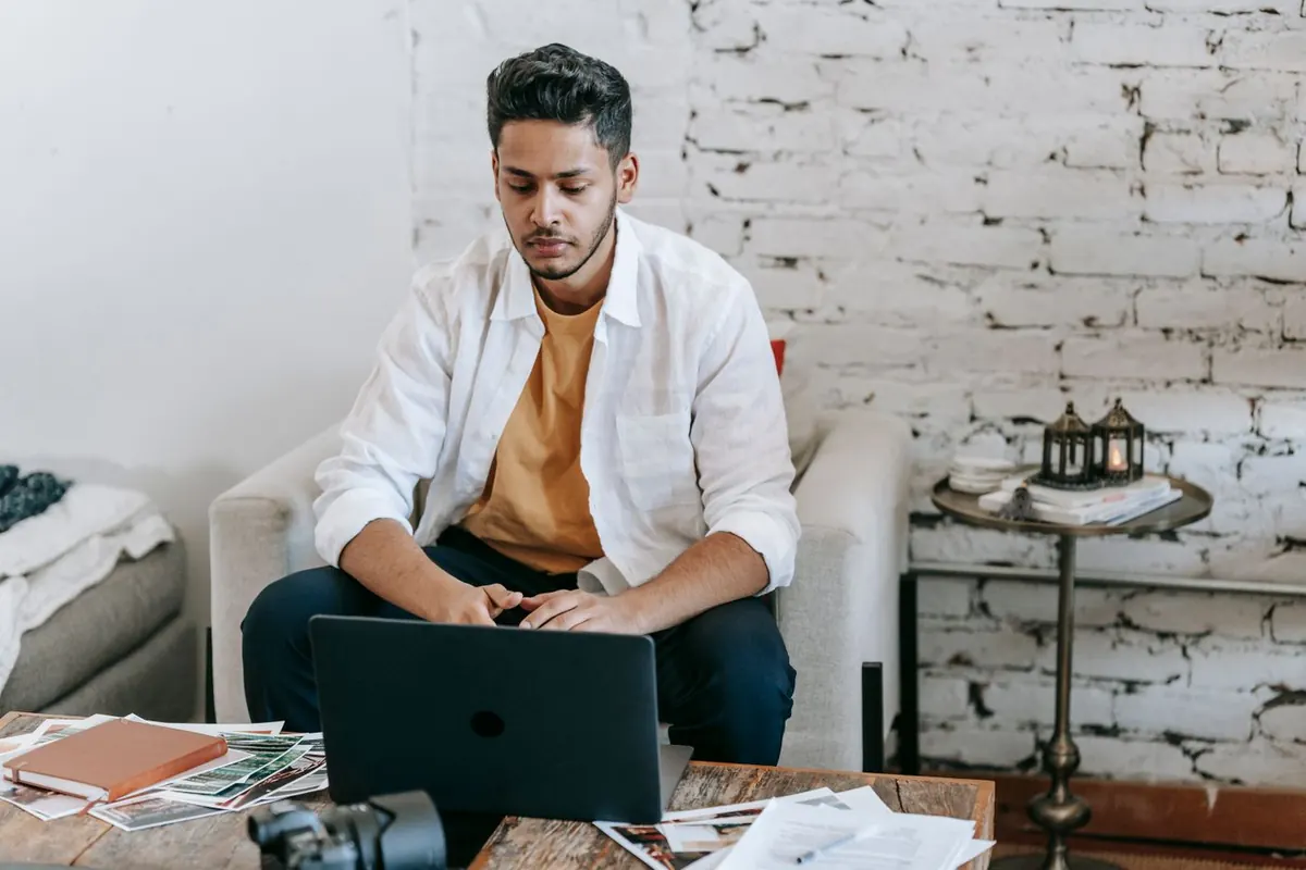 Un auto-entrepreneur travaillant sur son ordinateur portable avec des documents pour gérer ses impôts