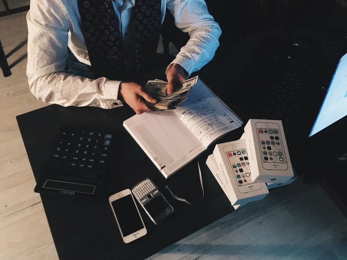 Loupe sur des pièces et des graphiques financiers, illustrant les frais d'investissement cachés