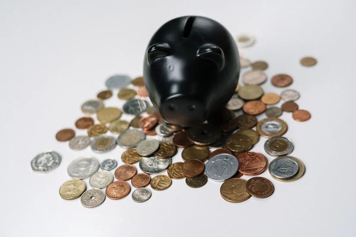 Tirelire et pièces à côté de documents financiers, livrets d'épargne en France