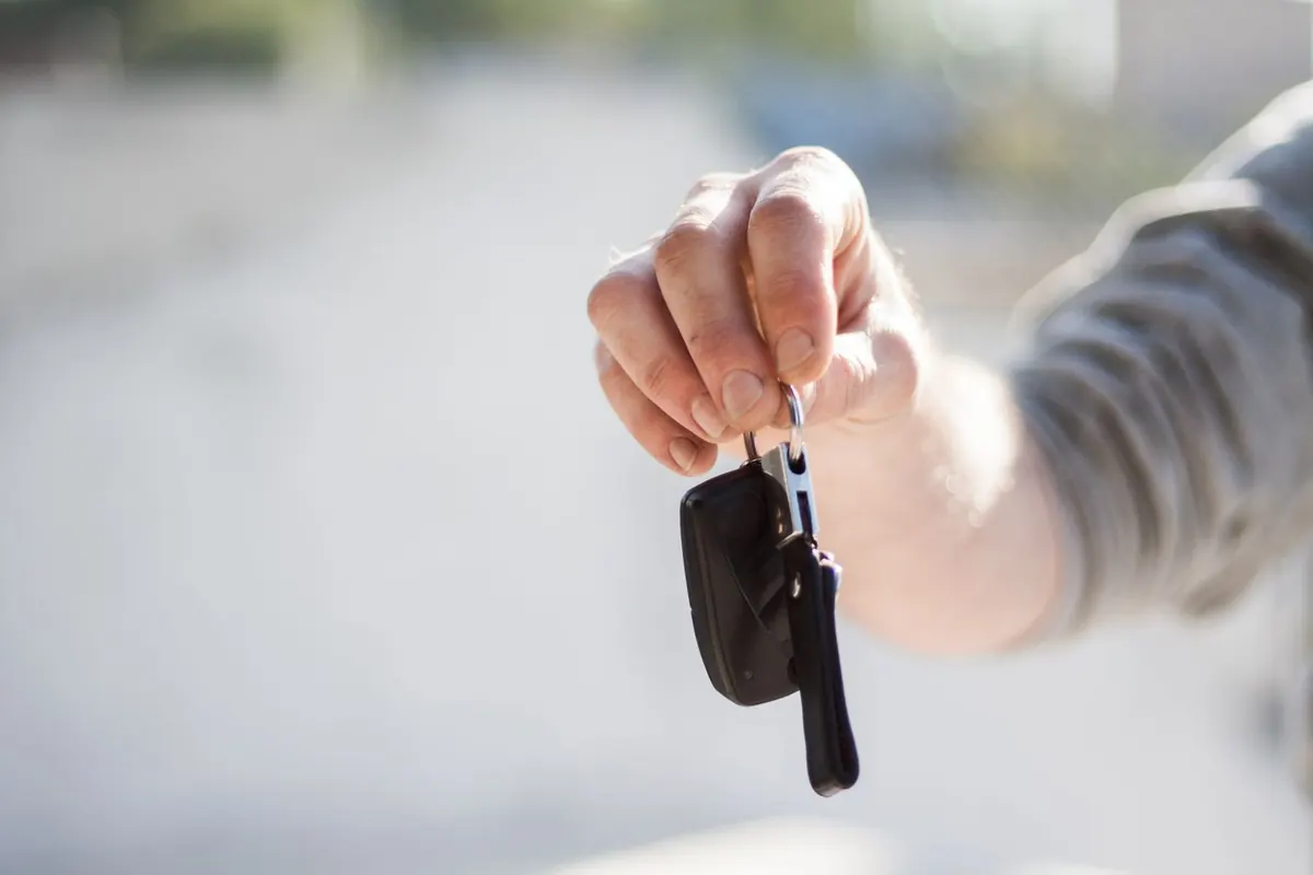 Mano sosteniendo las llaves de un coche, símbolo de la compra y financiación de un vehículo