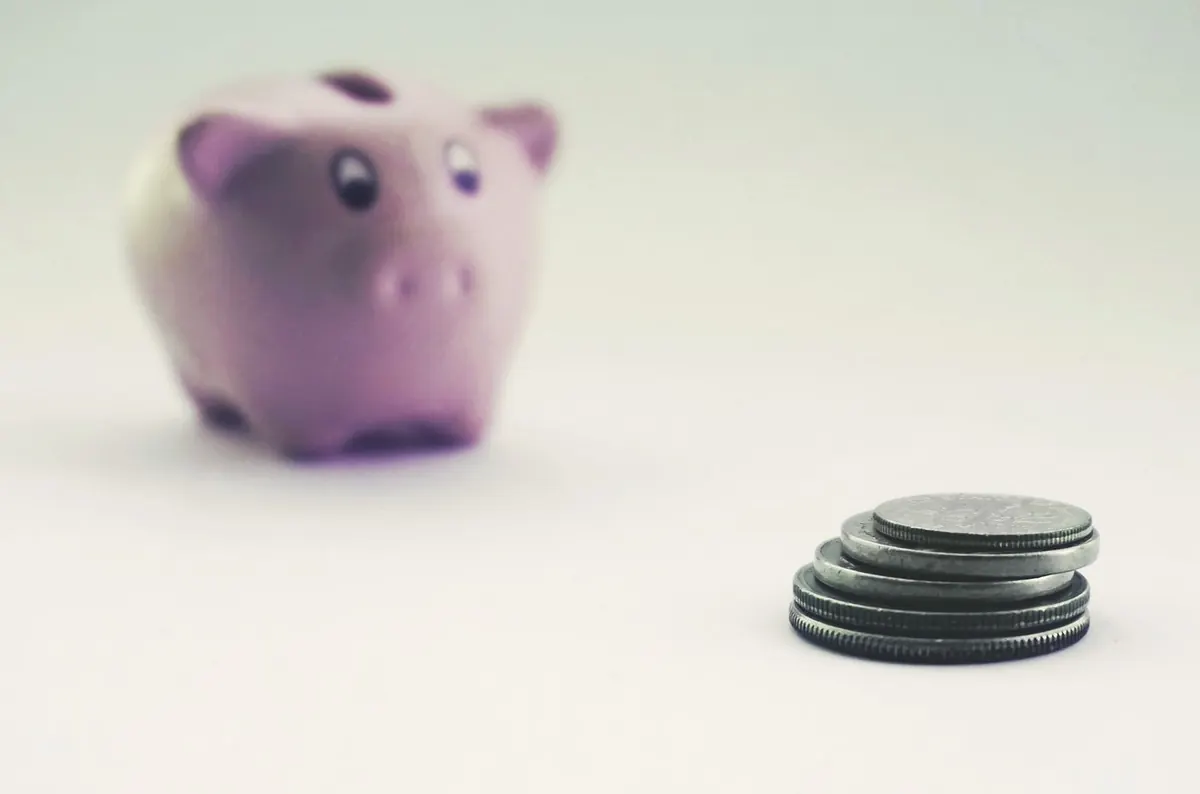 Hucha y monedas junto a documentos financieros, cuentas de ahorro y depósitos en España