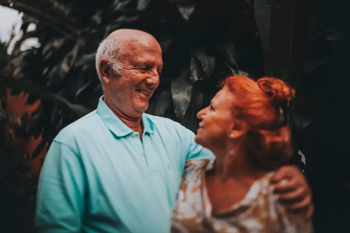 Pareja mayor sonriente y abrazada al aire libre, imagen de una jubilación tranquila en España